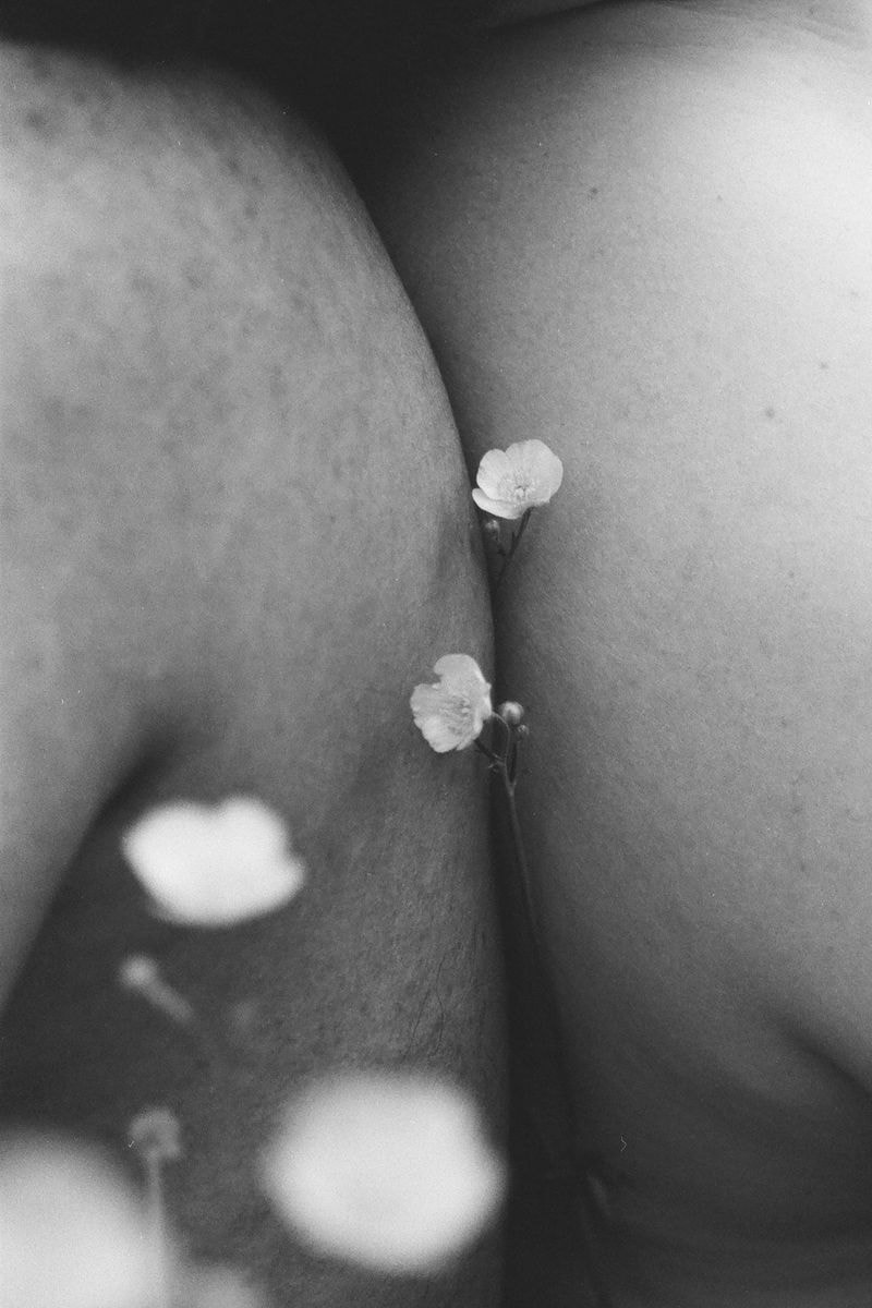 Zwart-wit foto van mannen met bloemen tussen hun ruggen