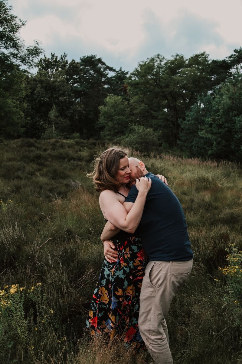 Koppel knuffelt liggend in het gras bij de Soesterduinen