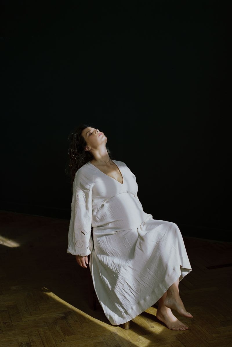 Pregnant woman in white dress in studio in Utrecht
