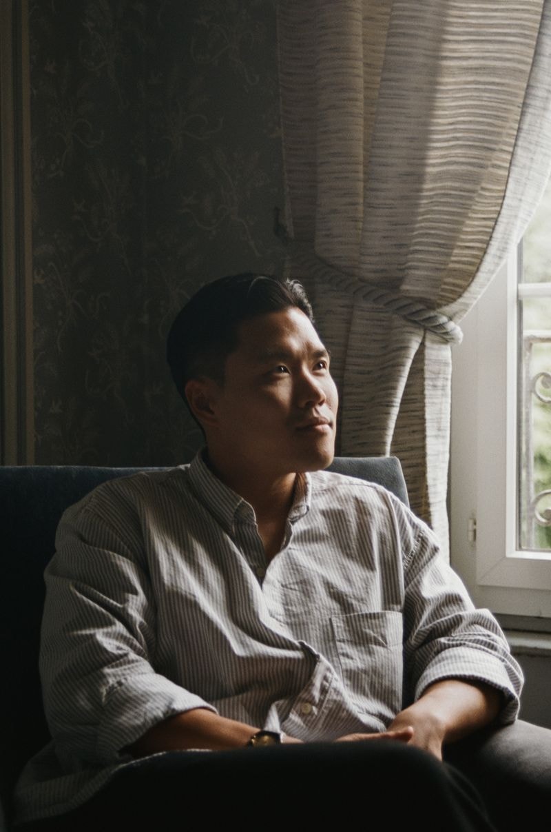 Man zittend voor een raam in een Frans kasteel voor een prachtige Noordelijke zon